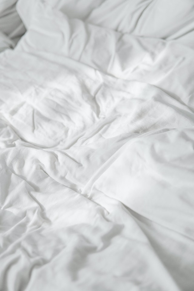 Wrinkled white sheets, one of the best ways how to check a hotel room for bed bugs