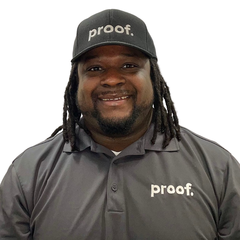 Leroy Glover, a proof. employee, wearing a grey proof. pest control shirt and hat. 