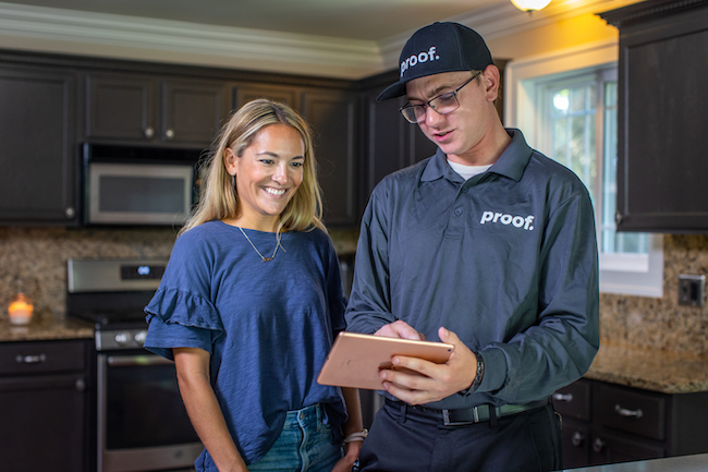 a proof. employee speaking to a woman inside her home