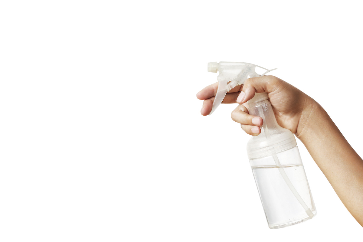 White plastic hand spray bottle with a simple white background. Flea house spray